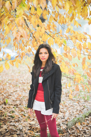 young beautiful indian woman at the park in autumnの写真素材
