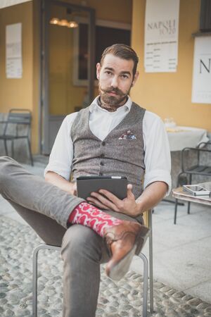handsome big moustache hipster man using tablet sitting at the barの写真素材