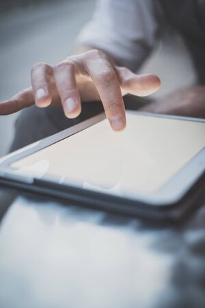 close up hand man using tablet at the bar with beer on table