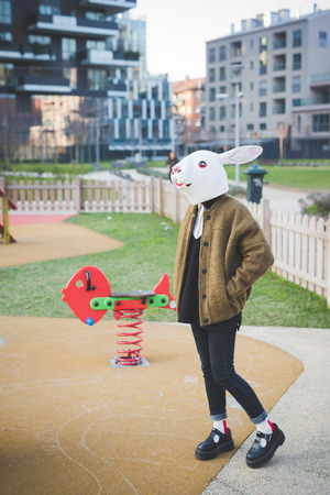 young beautiful asian hipster woman in the city - wearing rabbit mask - concept carnival, halloween, crazyの写真素材
