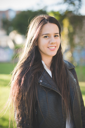 young beautiful long hair woman in town during sunset backlightの写真素材