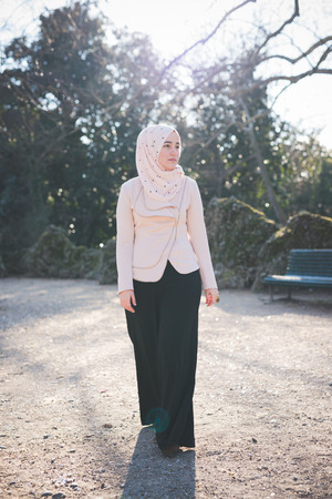 young beautiful muslim woman at the park in springの写真素材