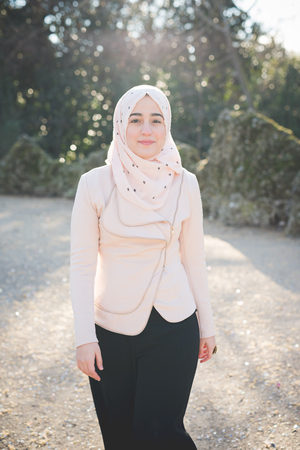 young beautiful muslim woman at the park in springの写真素材