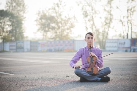 young crazy funny musician violinist asian man in town outdoor lifestyleの写真素材