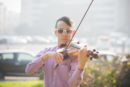 young crazy funny musician violinist asian man in town outdoor lifestyleの写真素材