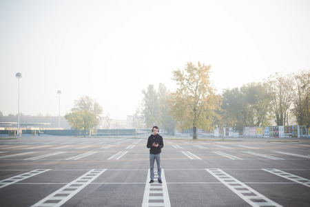 young crazy funny asian man in town outdoor lifestyle listening music with headphonesの写真素材