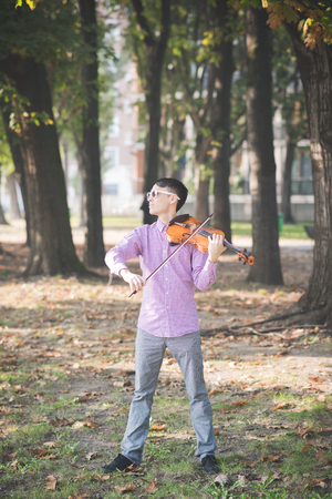 young crazy funny musician violinist asian man in town outdoor lifestyleの写真素材