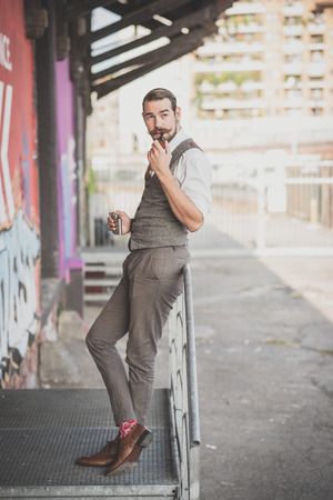 handsome big moustache hipster man smoking pipe in the cityの写真素材