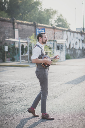 handsome big moustache hipster man playing mandolin in the cityの写真素材
