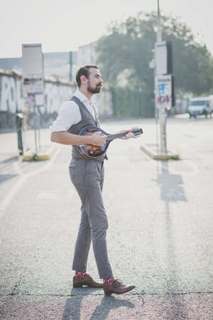 handsome big moustache hipster man playing mandolin in the cityの写真素材