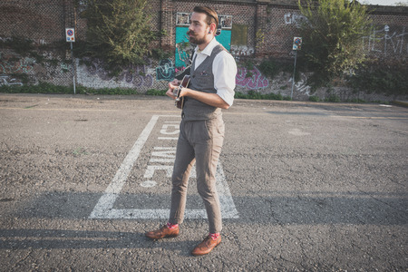 handsome big moustache hipster man playing mandolin in the cityの写真素材