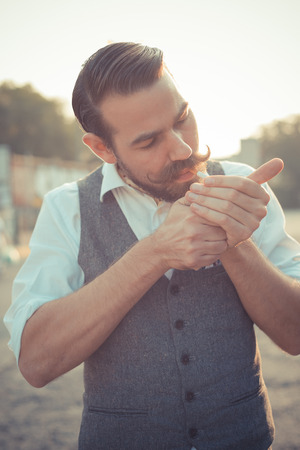 handsome big moustache hipster man smoking cigarette in the cityの写真素材