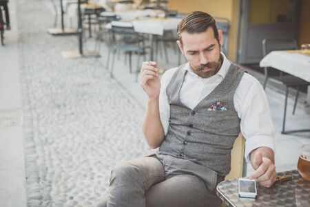 handsome big moustache hipster man using smart phone in the cityの写真素材
