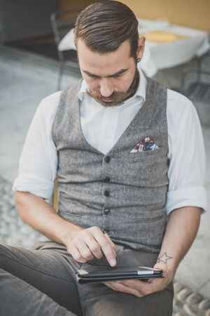 handsome big moustache hipster man using tablet sitting at the barの写真素材