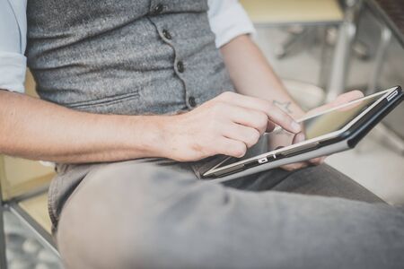 handsome big moustache hipster man using tablet sitting at the barの写真素材