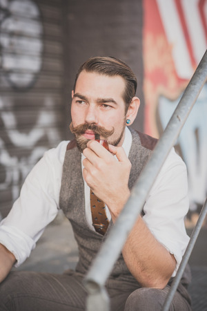 handsome big moustache hipster man smoking pipe in the cityの写真素材