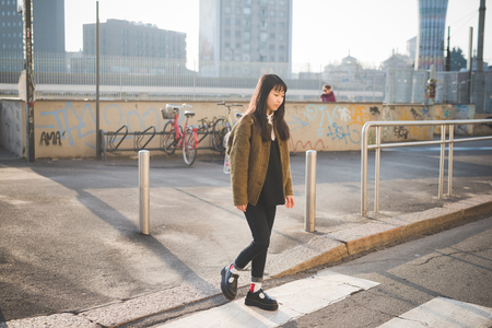 young beautiful asian hipster woman in the city - walking the street crosswalk having funの写真素材