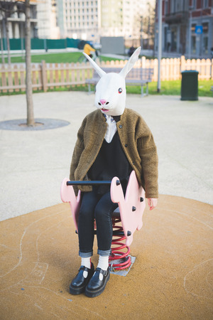 young beautiful asian hipster woman in the city - wearing rabbit mask - concept carnival, halloween, crazyの写真素材