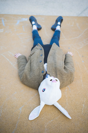 young beautiful asian hipster woman in the city - wearing rabbit mask - concept carnival, halloween, crazyの写真素材