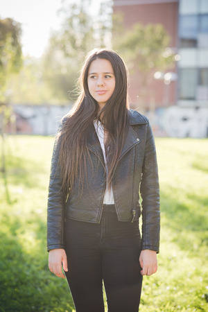 young beautiful long hair woman in town during sunset backlightの写真素材