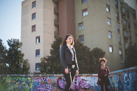two multiethnic beautiful young woman black and caucasian having fun in townの写真素材