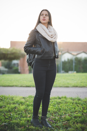 young beautiful long hair woman in town during sunset backlightの写真素材