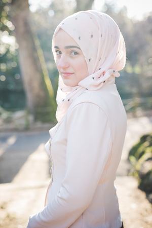 young beautiful muslim woman at the park in springの写真素材