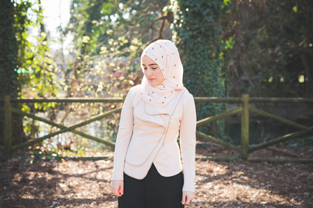 young beautiful muslim woman at the park in springの写真素材