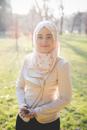 young beautiful muslim woman at the park in springの写真素材