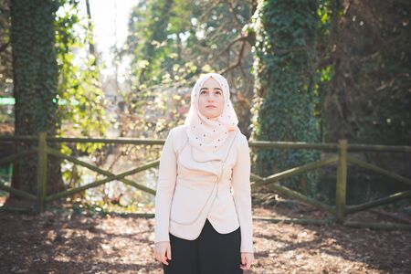 young beautiful muslim woman at the park in springの写真素材