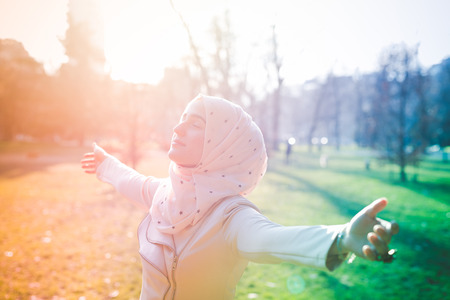 young beautiful muslim woman at the park in springの写真素材