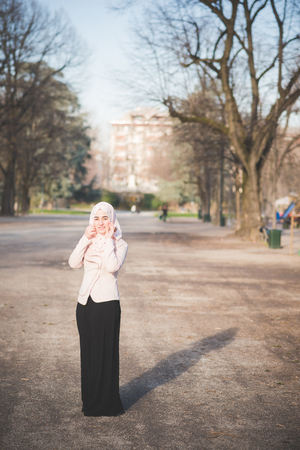 young beautiful muslim woman at the park in springの写真素材