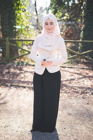 young beautiful muslim woman at the park in springの写真素材
