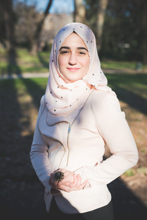 young beautiful muslim woman at the park in springの写真素材