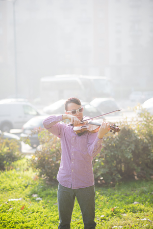 young crazy funny musician violinist asian man in town outdoor lifestyleの写真素材