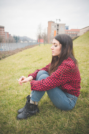 young beautiful long hair model woman living the city in winter outdoor city smoking cigaretteの写真素材
