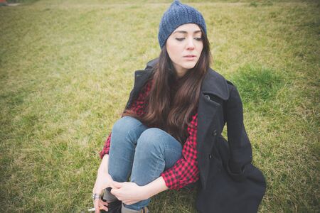 young beautiful long hair model woman living the city in winter outdoor city smoking cigaretteの写真素材