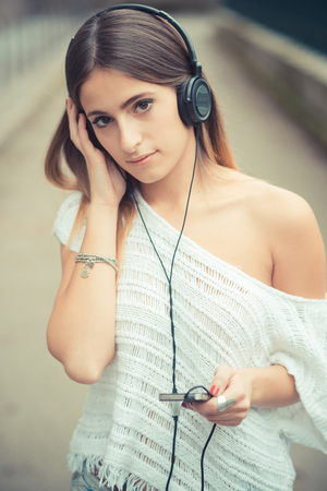 young beautiful woman girl autumn listening music outdoorの写真素材