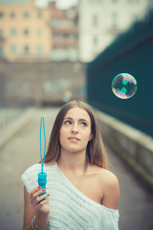young beautiful woman girl autumn blowing bubbles soup outdoorの写真素材
