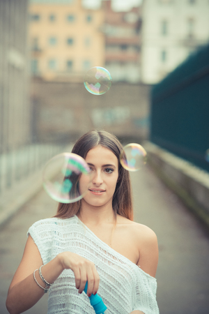 young beautiful woman girl autumn blowing bubbles soup outdoorの写真素材