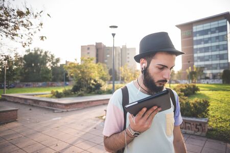 young handsome hipster gay modern man using tablet in townの写真素材