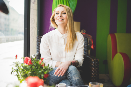 young beautiful blonde straight hair woman in the city sitting at the restaurantの写真素材