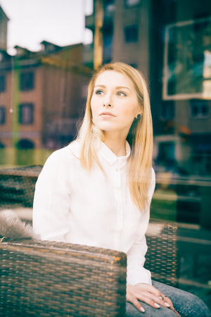 young beautiful blonde straight hair woman in the city sitting at the restaurantの写真素材