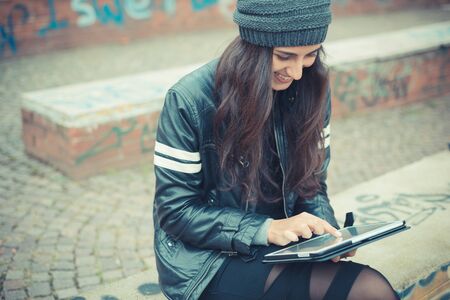 young beautiful brunette woman using tablet in the cityの写真素材