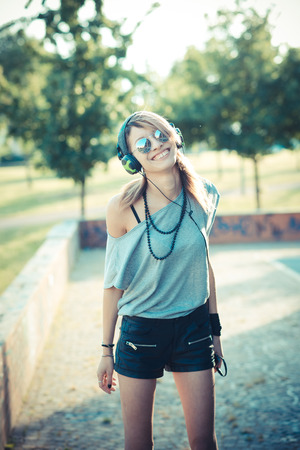 young beautiful model woman listening music in the cityの写真素材
