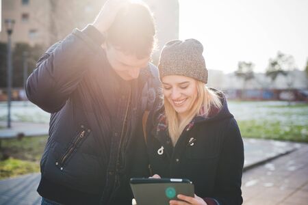 young couple lovers authentic using tablet connected online in the cityの写真素材