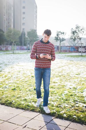 young handsome man using smartphone in the cityの写真素材