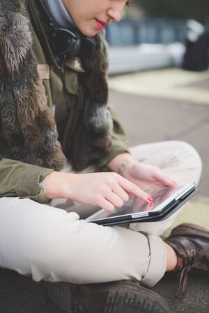 young beautiful short hair hipster woman in town using tablet technological device connected wirelessの写真素材