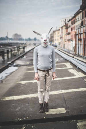 surreal woman with a rabbit mask - conceptual shot in urban landscapeの写真素材