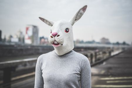 surreal woman with a rabbit mask - conceptual shot in urban landscapeの写真素材